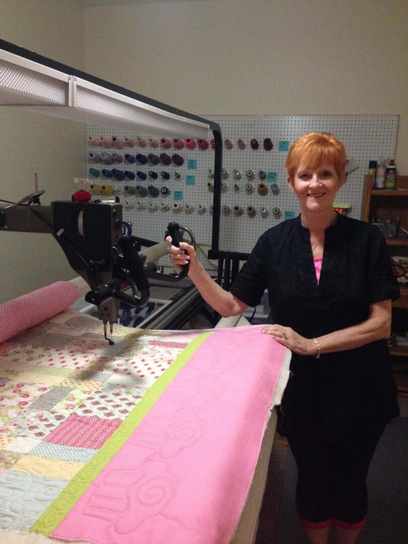 A woman standing in front of a sewing machine.