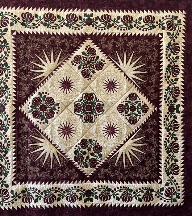 A quilt with purple and white designs on it.